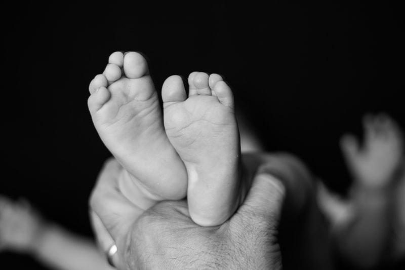 father holding baby feet